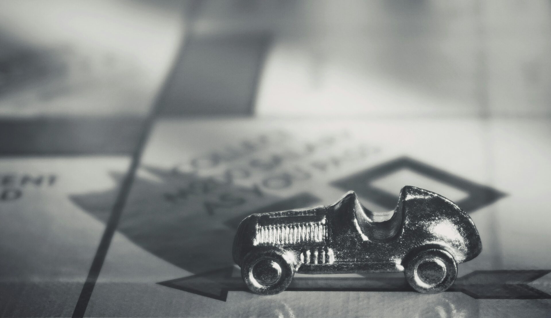 Pion voiture sur un plateau de Monopoly, symbolisant les dettes ou le patrimoine d’un couple marié