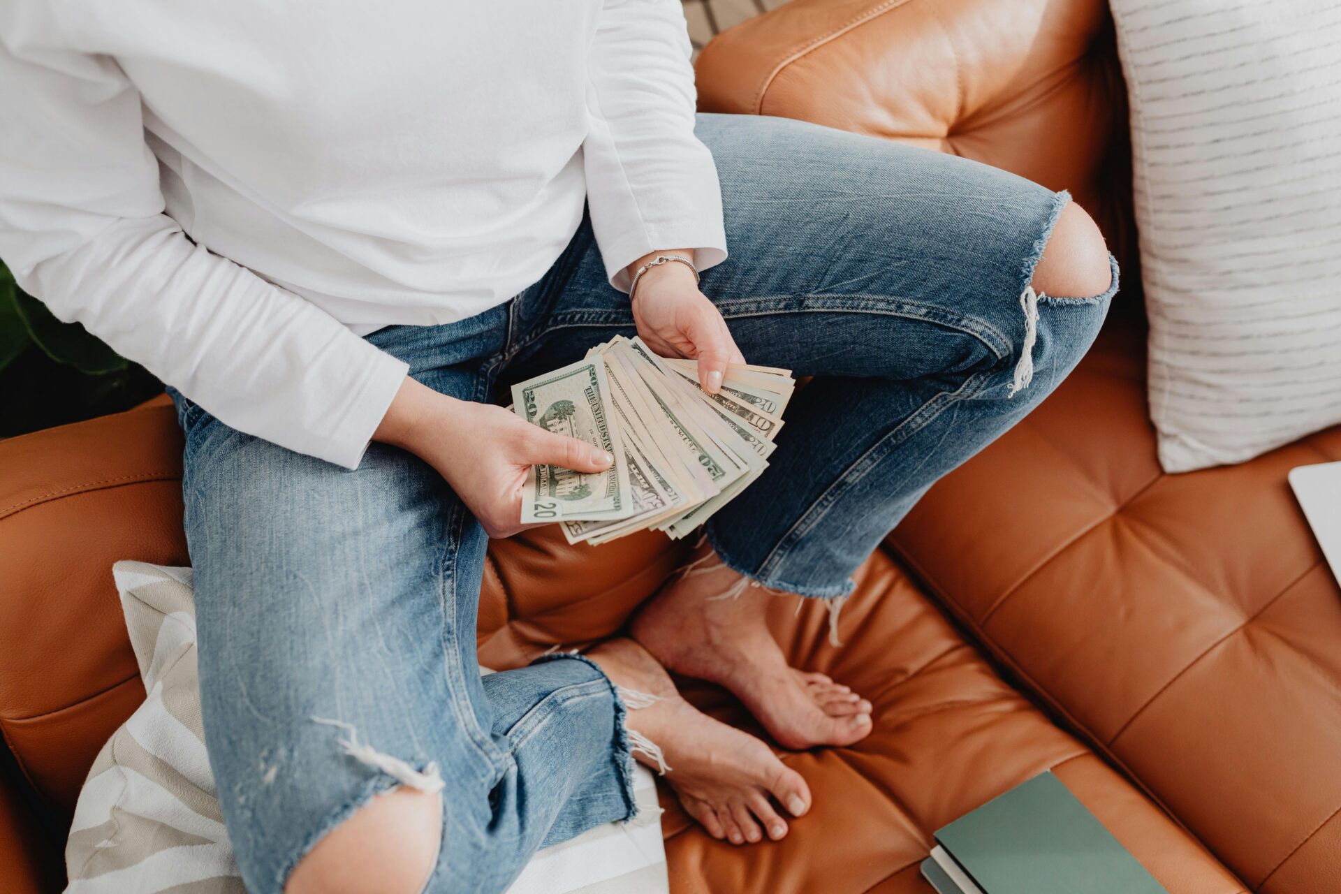 Personne tenant des billets, illustrant une dissimulation de liquidités lors d’un divorce