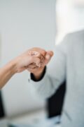 Deux personnes se saluent du poing, symbolisant un accord amiable dans le cadre d’un divorce ou d’un partage des biens